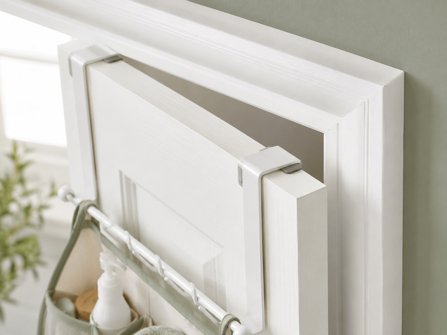 Close-up of an over-the-door bathroom storage hook showing door thickness, frame clearance, and protective padding